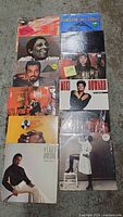 Full grouping of 12 various soulful music LP albums arranged on the floor, showing cover artwork of each record, mostly portraits of the artists.