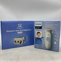 Front view of both product boxes: Philips kid-friendly hair clipper and Makartt Electric Nail Drill Machine JD700.
