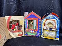 Three Muffy Stuffy Bears in their holiday-themed display boxes showing front views and overall set.