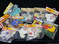 Photo showing multiple original packaged outfits from The Muffy Vanderbear Collection, including sweaters and colorful dresses.