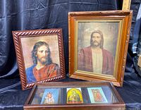 Two framed religious art prints of Jesus with a shadow box containing three religious images