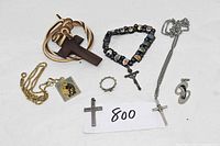 Photo showing various religious jewelry items including several crosses, bracelets, pendants, and rings.