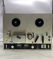 Front view of Roberts 450 reel-to-reel tape recorder showing the two reel hubs, control levers, knobs, and switches on metallic panel.
