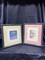 Two framed Jonathan Heath signed and numbered prints, one with pink matte and one with beige matte, displayed against black cloth.
