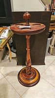Full view of vintage two-toned wooden floor stand showing the turned pedestal and round top with central finial.