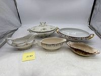 Full set showing all five pieces: one covered serving dish, one open serving dish, and three distinct gravy boats.