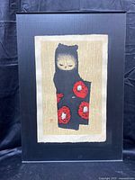 Full view of the woodblock print mounted on black plastic backing, showing the artwork and texture of the paper.