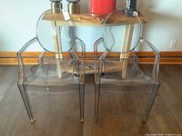 Front view of two matching clear acrylic ghost armchairs