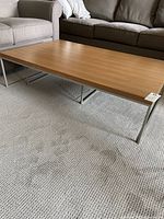 Large rectangular coffee table wood top metal frame on carpet