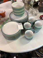 Full set stacked on table showing plates, bowls, mugs