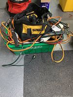 Green bin with DeWalt bag and assortment of extension cords