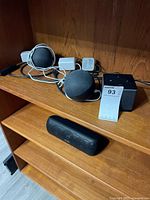 Overall view showing two Echo Dots with adapters, Fire TV Cube and Soundcore speaker on shelf