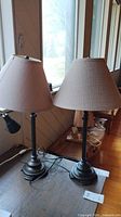 Both matching metal table lamps with shades on table
