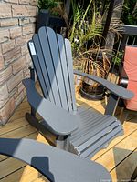 Full view of dark grey resin Muskoka chair on deck