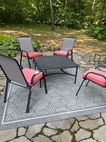 Full patio set showing four chairs, table and rug