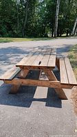 Full view of wooden picnic table showing top, benches and A-frame legs