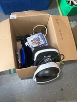Box containing PlayStation VR headset, two PS4 game cases and cables