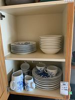Cabinet showing stacks of dinner and luncheon plates, bowls