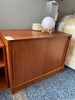 Full view of teak credenza next to bed
