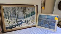 Framed acrylic painting of a winter scene with birch trees and creek, showing the whole framed artwork laid horizontally.