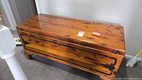Front angle view of the Cavalier cedar hope chest showing wood grain and metal accents on top and side panels.