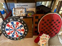 Image showing the backgammon set with game tiles and dice, the dartboard, a wooden folding game board and boxed game set, and juggling balls.