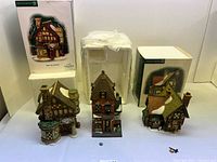 Three ceramic village houses with two original boxes and loose accessories visible