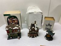 Front view of three ceramic Department 56 buildings with two boxes behind