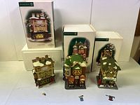 3 Department 56 Dickens Village lighted buildings displayed, original boxes behind, accessories in front.