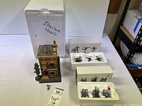 Overview of village building, packaging and two figurine sets
