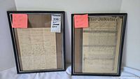 Front view of two framed historical indenture documents side by side with size notes.