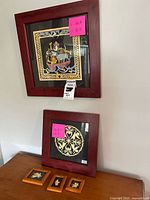 All five framed papercut mixed media wall art pieces displayed on a surface and hung on wall, showing frame detail and art layout.
