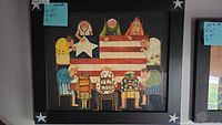 Front view of framed folk art print depicting women sewing an American flag, measuring 17" H x 20" W with black frame and star accents