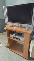 Rolling media cabinet with a TV on top in a room, cabinet size about 27x16x31 inches