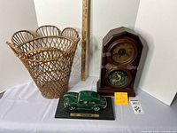 Wicker basket, vintage mantel clock, and Volkswagen model car displayed together with measuring ruler for size reference.