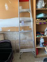 Full view of 6-ft aluminum step ladder leaning against wall