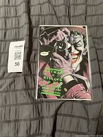 Front cover of Batman: The Killing Joke graphic novel in protective sleeve