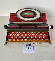 Overall view of Simplex Model 300 toy typewriter showing dial, keyboard plate and paper roller