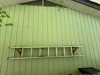 Ladder stored horizontally on wall brackets