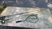 Full view of two rod & reel combos and landing net on table