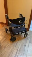Rollator walker opened, showing seat, backrest, storage pouch and wheels