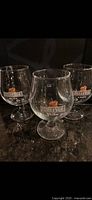 Three Belle-Vue Kriek stemmed snifters/goblets on countertop