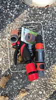 Basket containing assorted hose fittings and sprayers