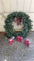 Full view of wreath and three boxes of red ornaments