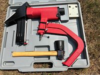 Open case displaying stapler, mallet, base plate inside molded compartments