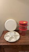 Divided white veggie tray with lid and three stacked red containers