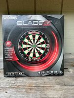 Front of boxed Winmau Blade 5 dartboard showing product graphics