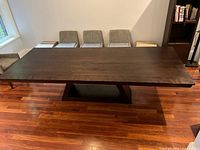 Full side view of dark wood dining table showing pedestal base