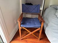 Front view of folding wood chair beside bed
