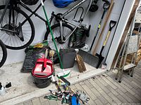 Overall view of garden tools, pails, bags of mulch and compost in shed